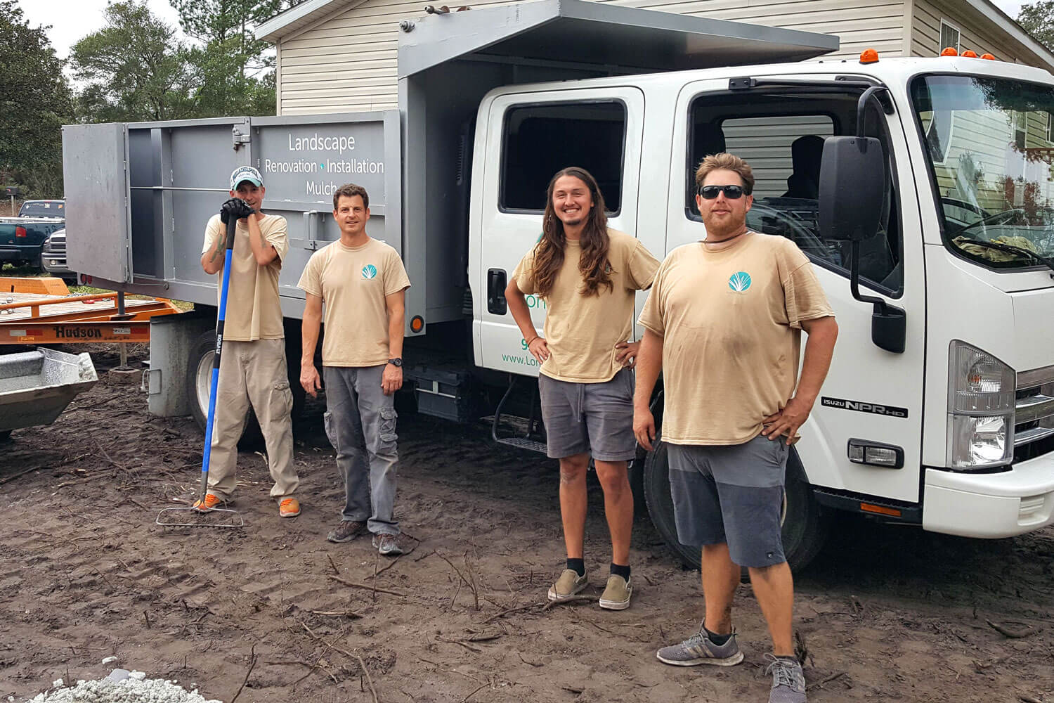 The Long Leaf Organics staff poses in from of a dump truck.